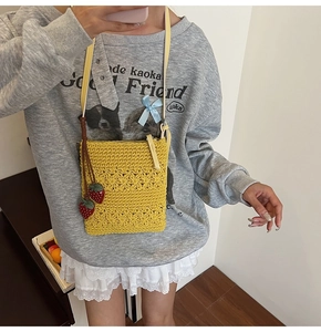 Vue détaillée du sac bandoulière au crochet jaune avec pendentif fraise et bandoulière