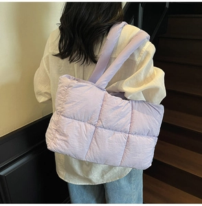 Quilted lavender puffer tote bag showing a large capacity design on a model back view