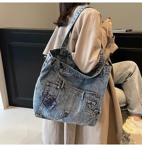 Detail of vintage denim tote bag showing distressed texture and jean pocket structure