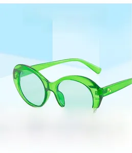 Detail of trendy oval sunglasses with translucent green frames on a blue geometric prop