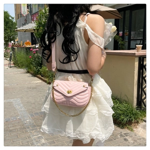 Detail shot of the pink V-quilted texture and gold chain strap of this elegant shoulder bag