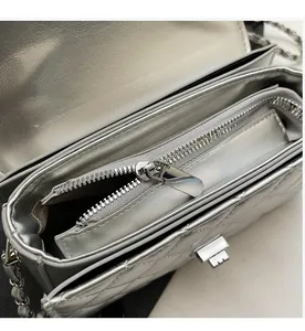 Detail shot of smooth silver metal zipper and quilted texture on the chain bag
