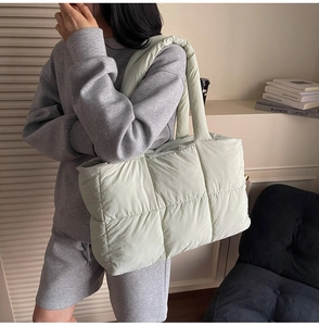 Mint green quilted puffer tote bag shown on shoulder for trendy casual street style