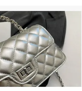 Detail of silver quilted handbag featuring a metallic finish and rectangular turn-lock