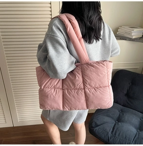 Detailed back view of a pink quilted puffer tote bag on a model shoulder in casual setting
