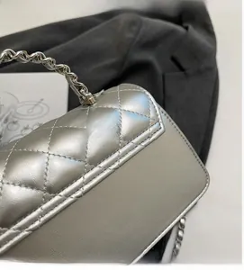 Detailed close-up of silver quilted crossbody bag with metallic chain strap and PU leather texture