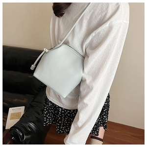 Litchi pattern leather bucket bag detail with stylish knotted shoulder strap feature