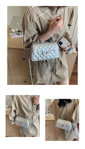 Close-up of metallic silver quilted crossbody bag with metal chain and turn-lock closure