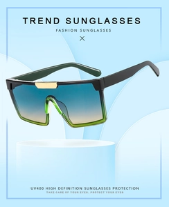 Détail de lunettes de soleil carrées oversize avec verres dégradés et pont doré