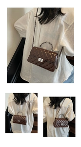 Detail of dark brown quilted leather bag featuring silver twist lock and dual chain straps