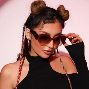 Fashionable model wearing retro hexagonal tortoiseshell sunglasses with brown gradient lenses