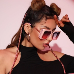 Chic oversized square sunglasses with pink glitter frames and gradient lenses on a model