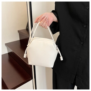 Detail of white lychee grain leather shell bag with drawstring and thin double handles