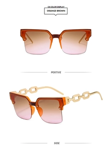 Détail de lunettes de soleil orange dégradé avec branches chaîne dorée et demi-monture