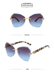 Detail of rimless gradient grey blue lenses with gold metal hinges and tortoise temples
