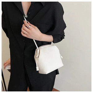 Vue détaillée du sac bandoulière blanc texturé litchi avec bandoulière à nœud minimaliste