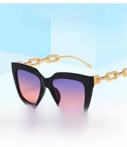 Détail des branches en chaîne dorée et verres dégradés sur des lunettes de soleil oversize