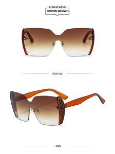 Detail view of oversized rimless sunglasses with brown gradient lenses and orange temples