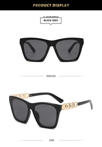 Detail view of square cat-eye sunglasses with black frames and gold chain temples