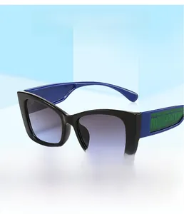 Détail de lunettes de soleil carrées avec branches bleues et accent vert sur le côté
