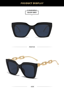 Détail de lunettes de soleil carrées noires avec branches en chaîne métallique dorée