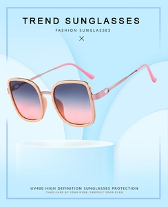 Détail de lunettes de soleil carrées avec monture or rose et verres dégradés bleu-rose