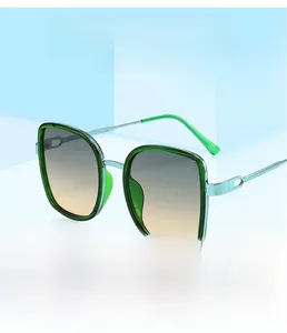 Détail de lunettes de soleil carrées vertes avec verres dégradés et charnières métalliques
