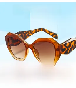 Close-up of polygon tortoise shell sunglasses on a blue geometric stage display