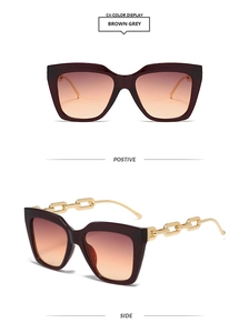 Détail de lunettes de soleil carrées avec branches chaîne dorée et verres dégradés gris