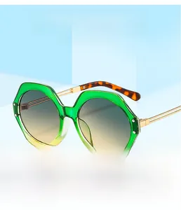Detail of gradient green hexagonal frames with gold metal temples and tortoise tips