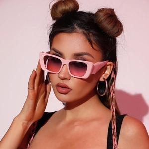Close-up of stylish rectangular pink sunglasses with gradient lenses on a fashion model