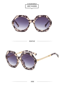 Detail view of hexagonal grey flower tortoise sunglasses with purple gradient lenses