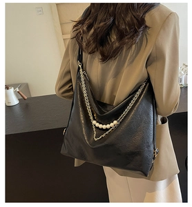 Détails du grand sac cabas noir avec une chaîne dorée élégante et des perles blanches