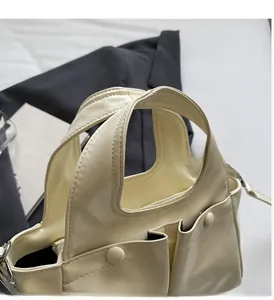 Detail of wide handles and pleated pockets on the beige oversized tote bag