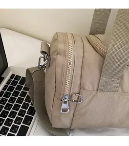 Detail of khaki fitness bag featuring side zipper pocket and durable metal hardware