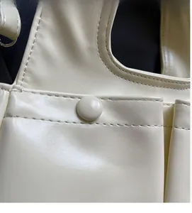 Close-up of cream leather bag showing fine stitching and smooth material texture