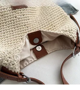 Close-up of crochet beach bag with magnetic buckle closure and brown leather trim detail