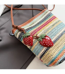 Gros plan d'un sac tressé à rayures colorées orné de charmantes fraises rouges