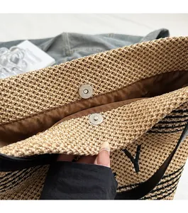 Close-up of magnetic snap closure and inner lining on large straw tote bag