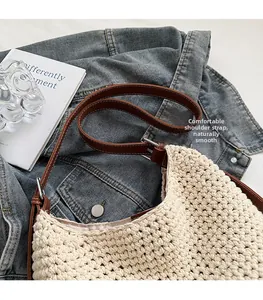 Detail of beige woven tote bag showing knitted texture and brown leather shoulder strap