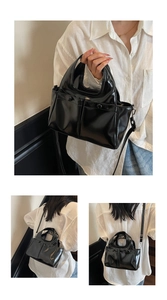 Detail showing glossy black PU leather tote with mirror finish and adjustable strap