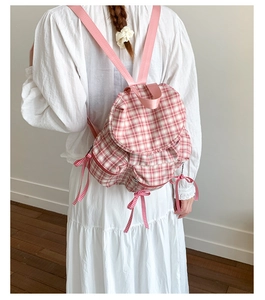 Vue arrière d'un mannequin portant le sac à dos en toile à carreaux roses et nœud