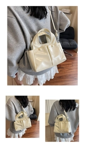 Detail of off-white glossy tote bag showing the textured finish and adjustable strap