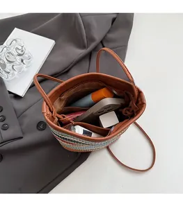 Détail du sac seau en paille colorée avec anses en cuir et espace de rangement interne
