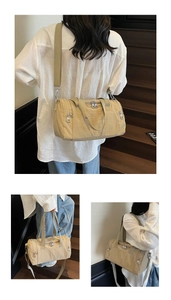 Detail of beige cylinder nylon gym bag with dual zippers and adjustable wide strap