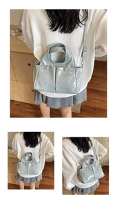 Detail of light blue glossy tote bag with pleated double front pockets and crossbody strap
