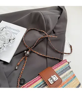 Detail of multi-color woven straw bucket bag with leather flap and silver metal twist lock