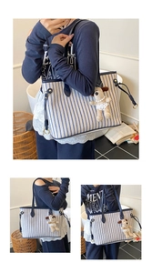 Detail of striped tote bag featuring blue leather trim and plush puppy charm