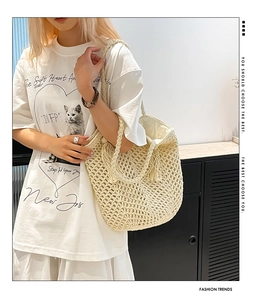Detail of hand-woven crochet bucket bag featuring thick cotton rope and boho tassels