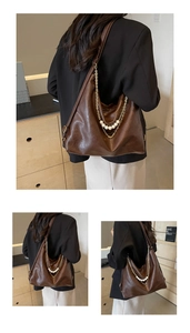 Détail d'un cabas en cuir marron foncé avec accents décoratifs de perles et chaîne